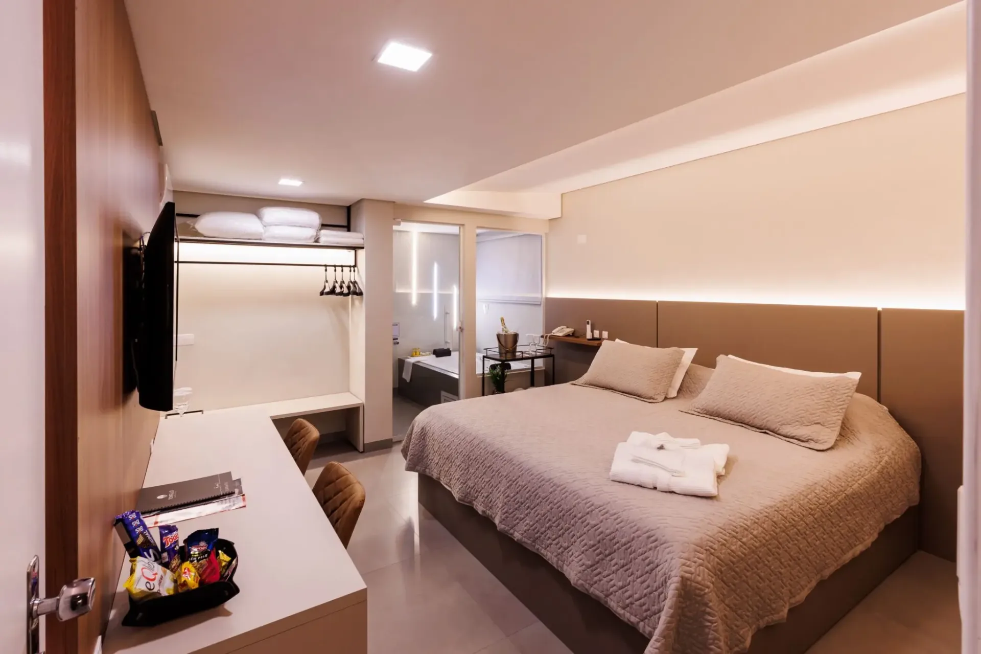 Suíte luxo com cama king-size, hidromassagem ao fundo e amenidades
